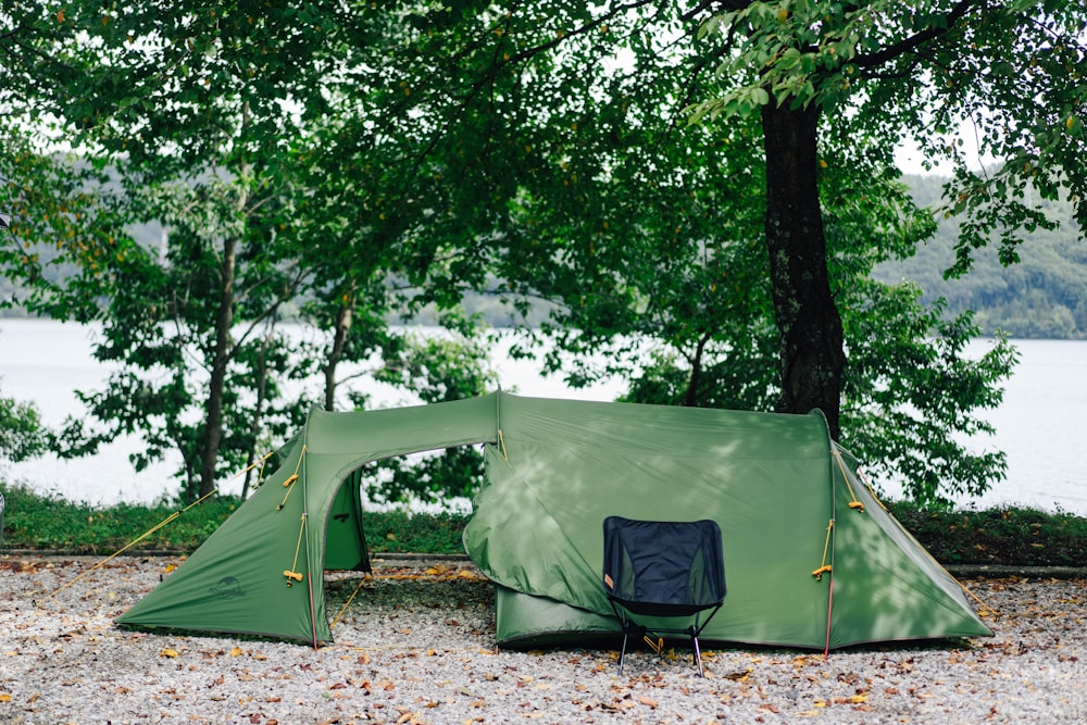 green tent under green trees during daytime