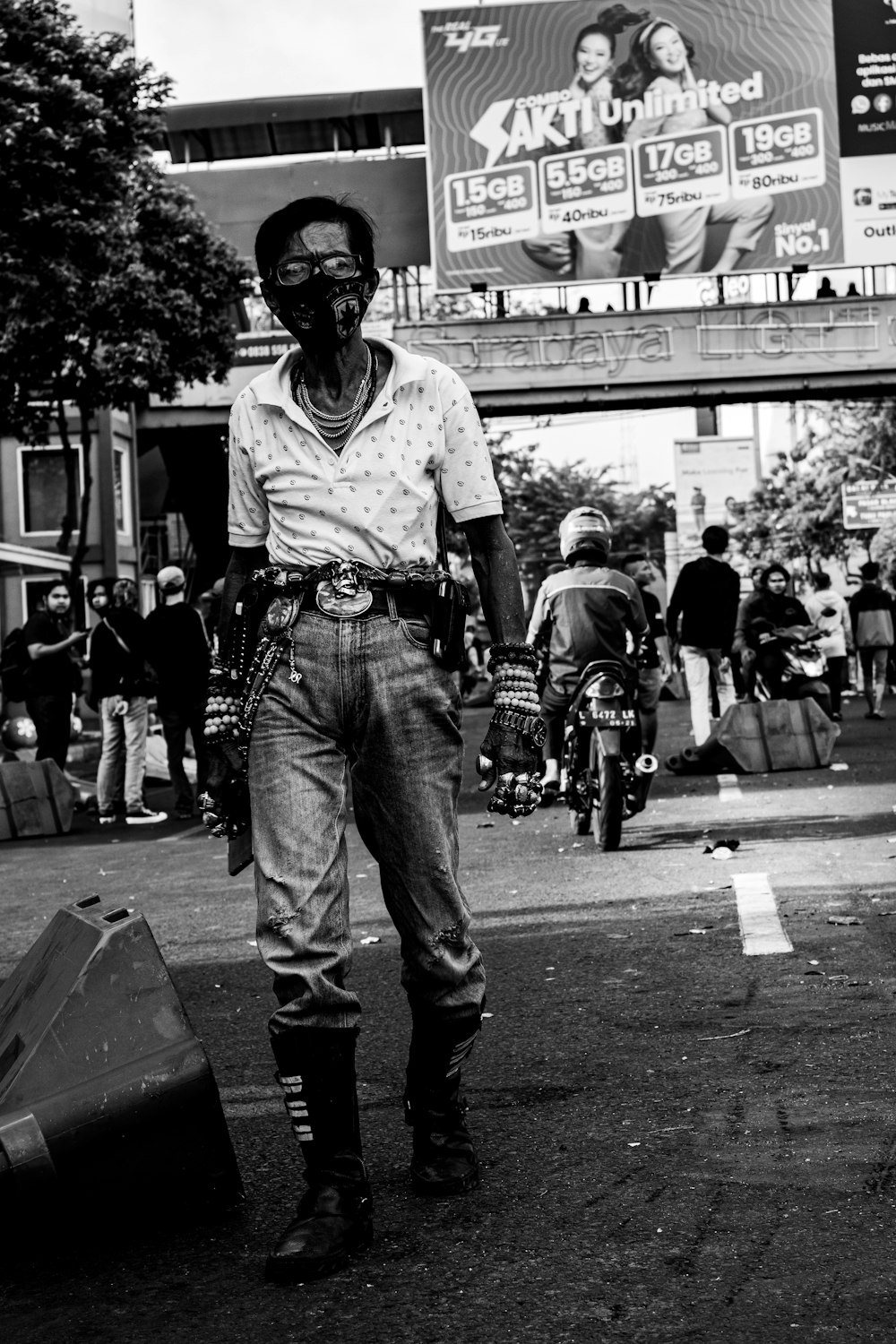 man in white t-shirt and blue denim jeans standing on street