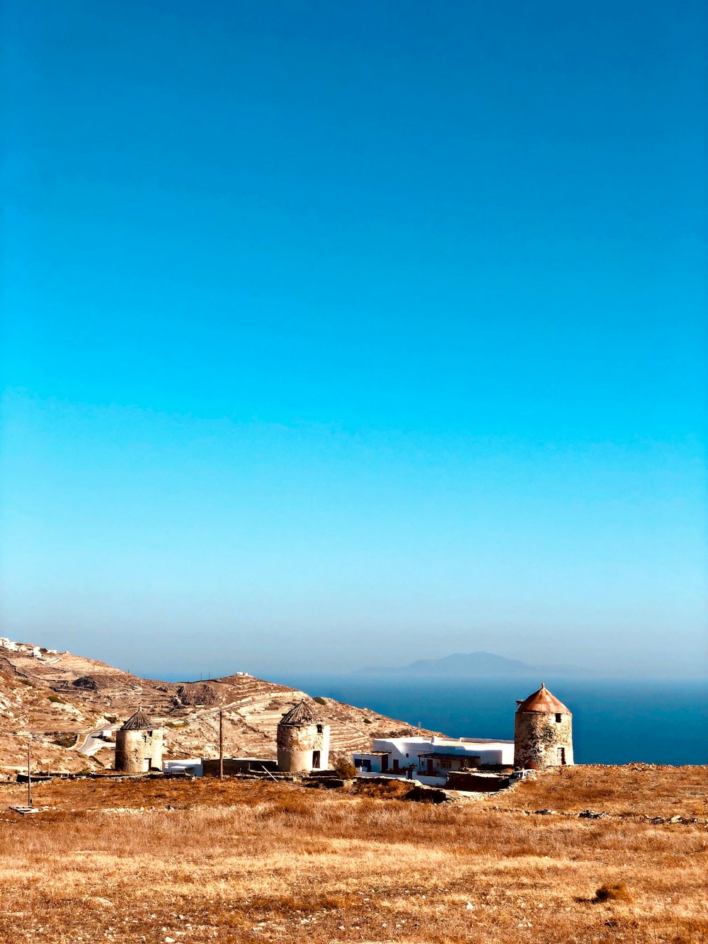 brown and white concrete houses near brown mountain under blue sky during daytime