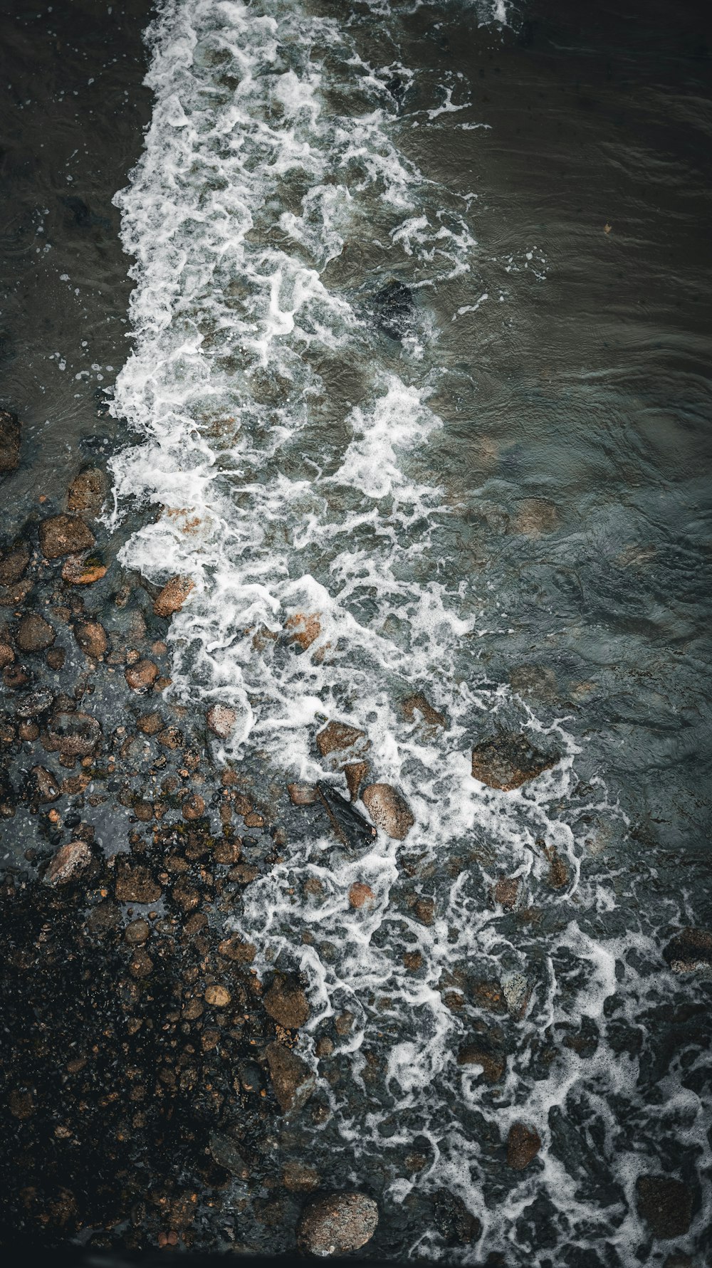 water waves hitting rocks on shore during daytime