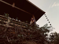 Guests enjoying a relaxed evening on the balcony surrounded by lush greenery.