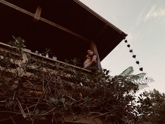 Smiling couple enjoying their renovated balcony with new decking and plants.