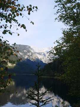 A serene landscape with mountains reflected in a calm lake.