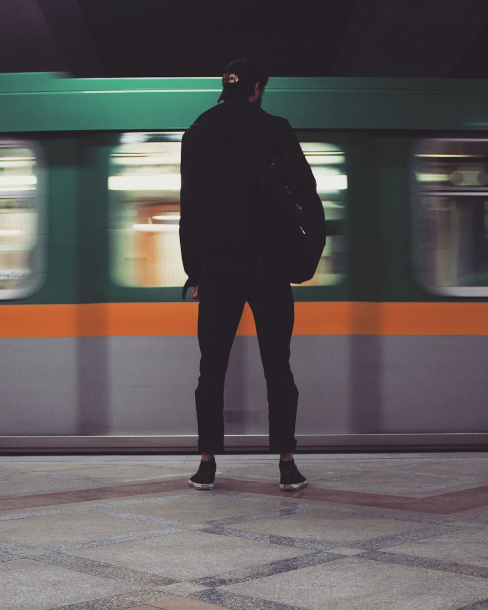 man in black jacket standing beside train