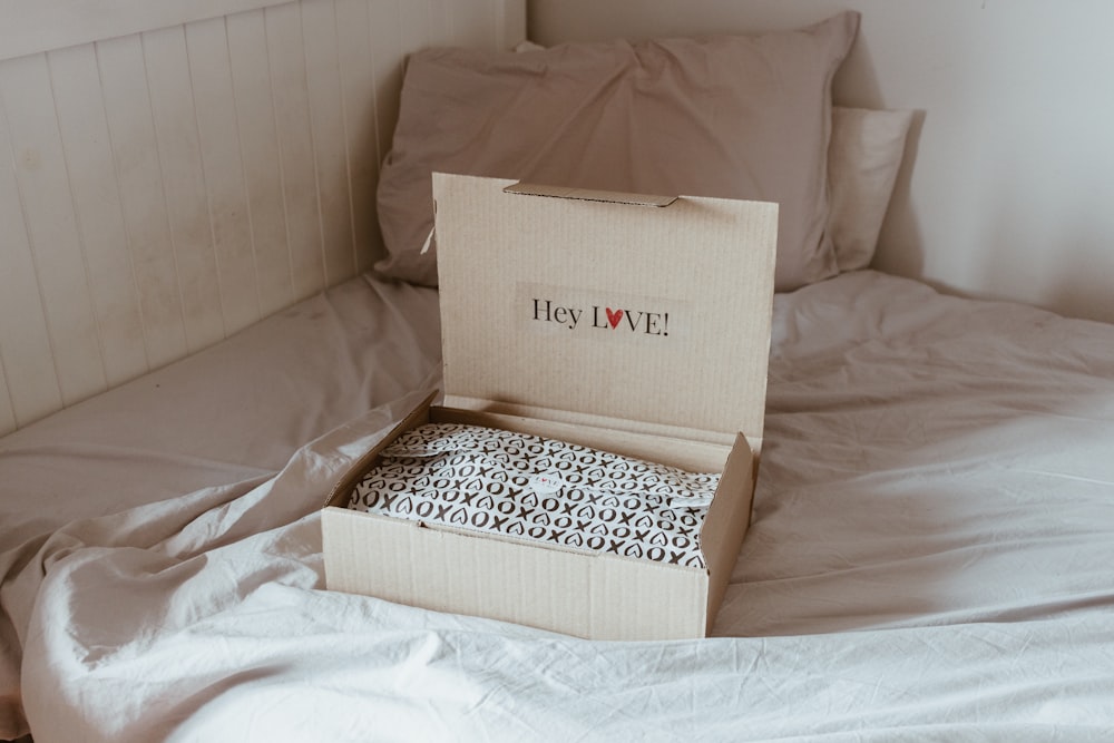 brown cardboard box on white and black textile