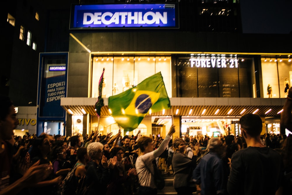 uma multidão de pessoas em pé na frente de um prédio