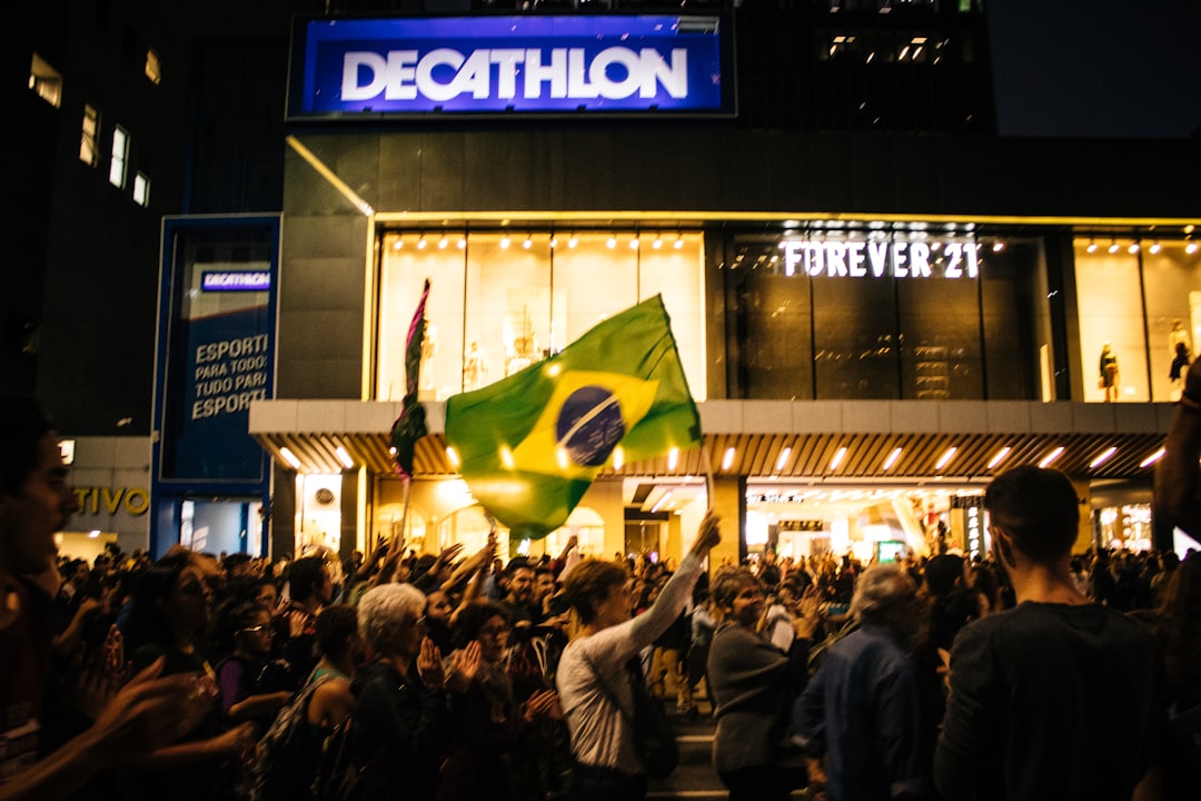 a crowd of people standing in front of a building, students protest against attacks from the bolsonaro