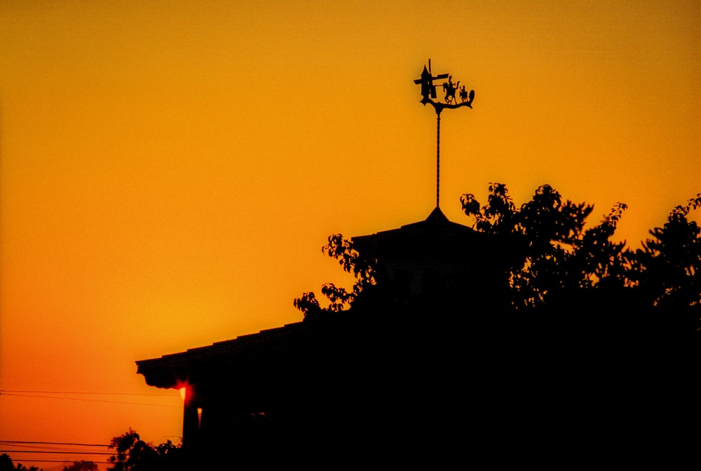 Silhouette von Baum und Haus bei Sonnenuntergang