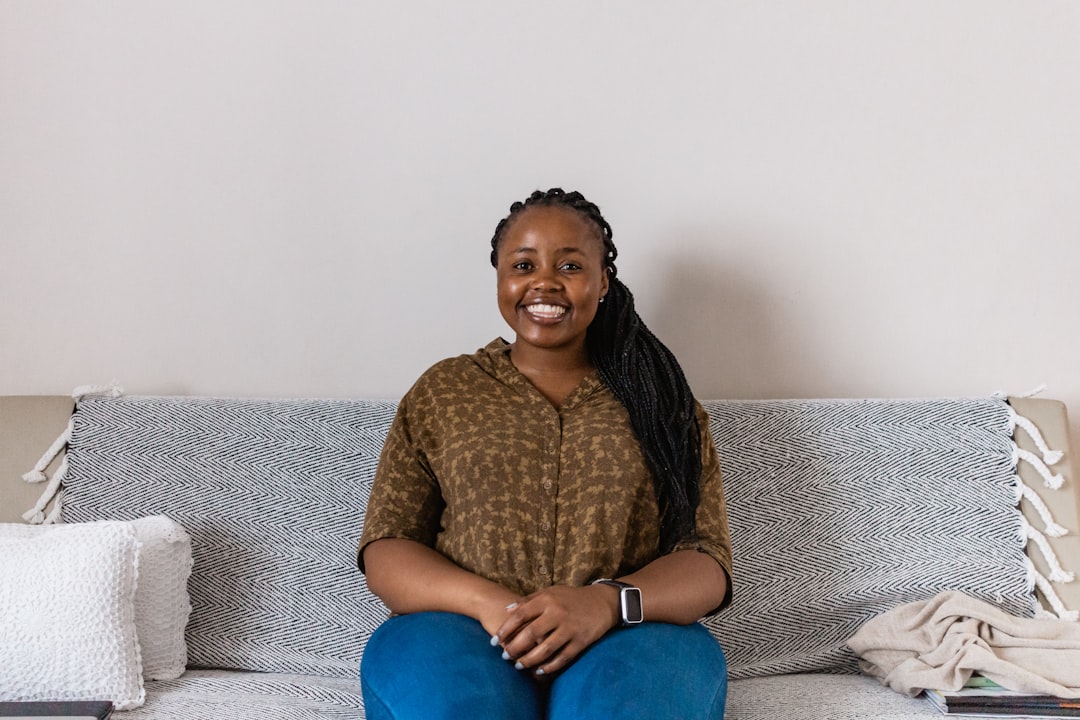 woman in brown long sleeve shirt sitting on gray couch