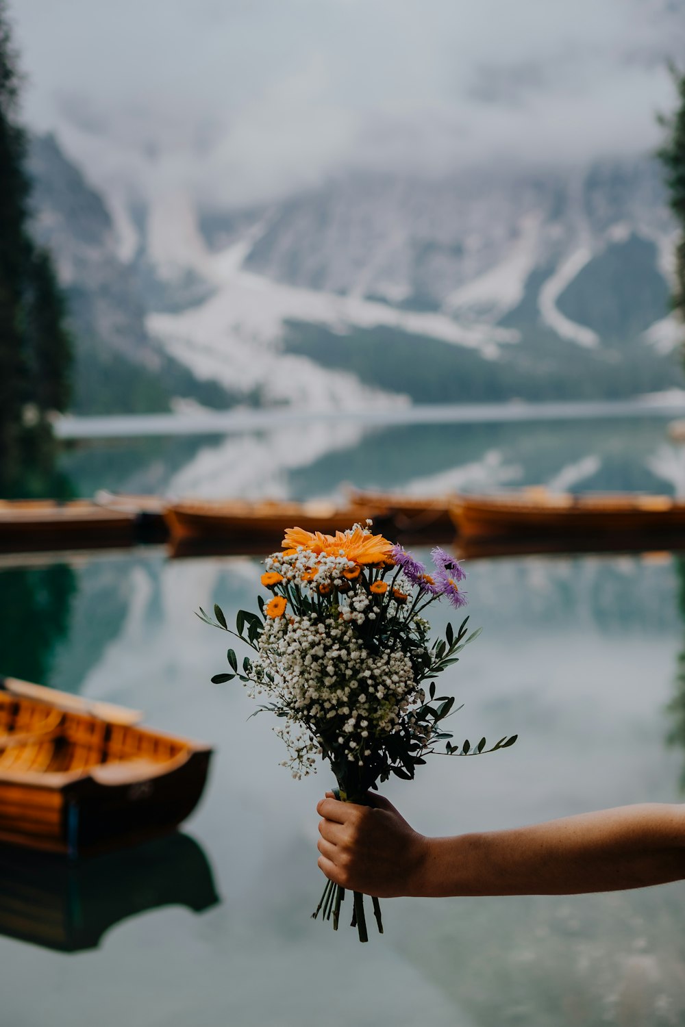 person holding yellow and purple flowers