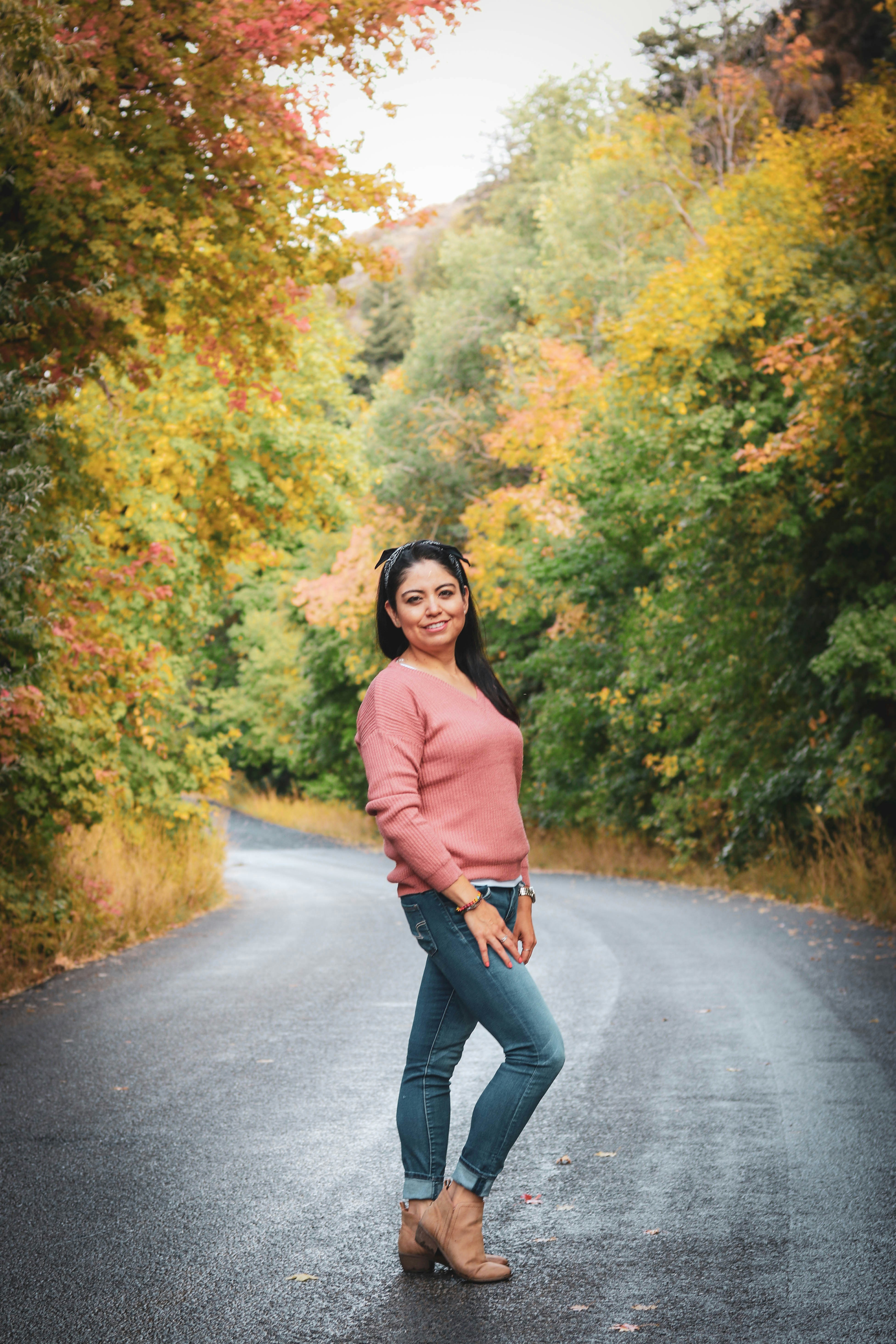 woman in brown long sleeve shirt and black pants standing on gray asphalt road during daytime