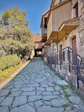 A sunlit path winding through vibrant Mediterranean hills and quaint village rooftops.