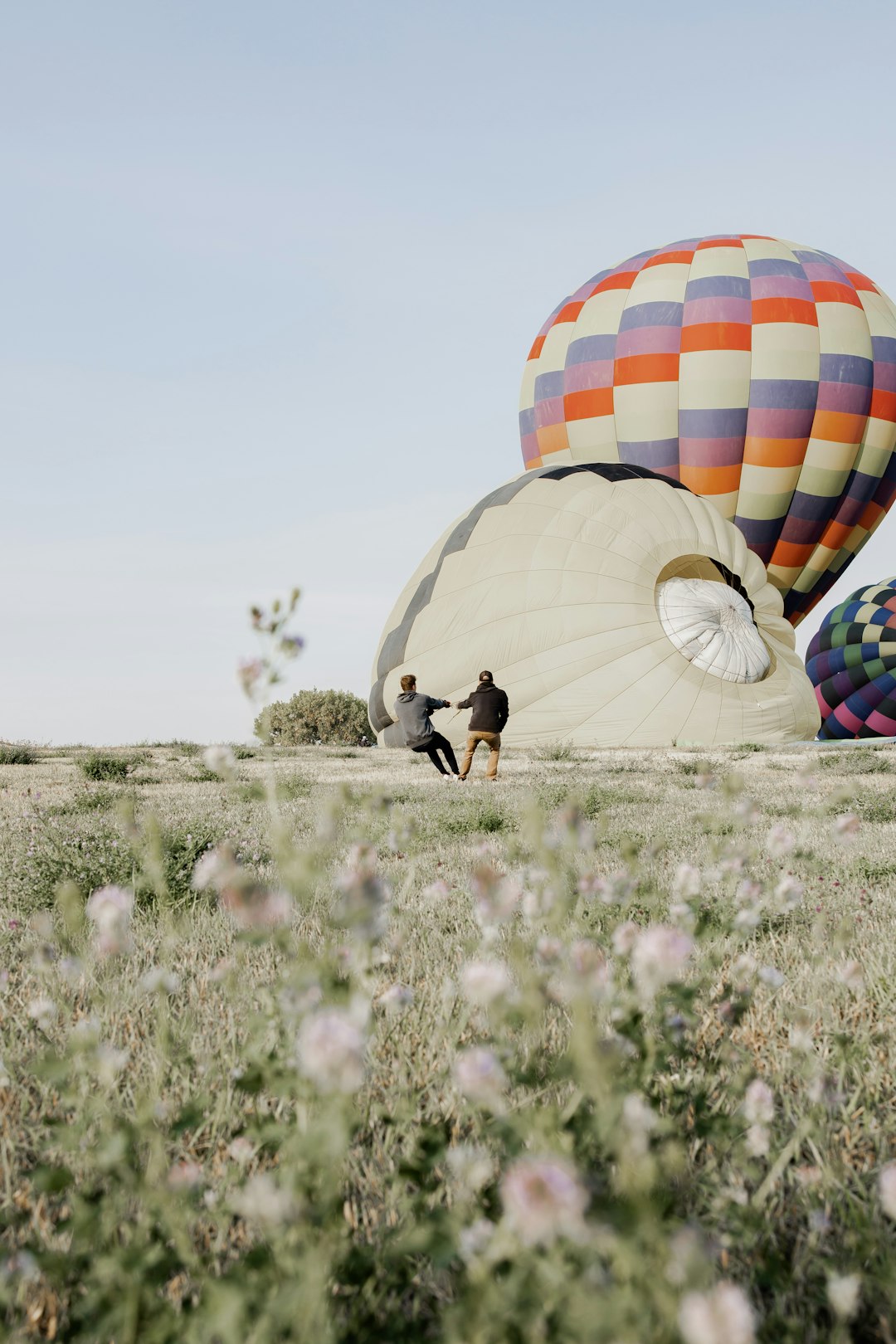 man in black shirt and black pants holding multi colored hot air balloon