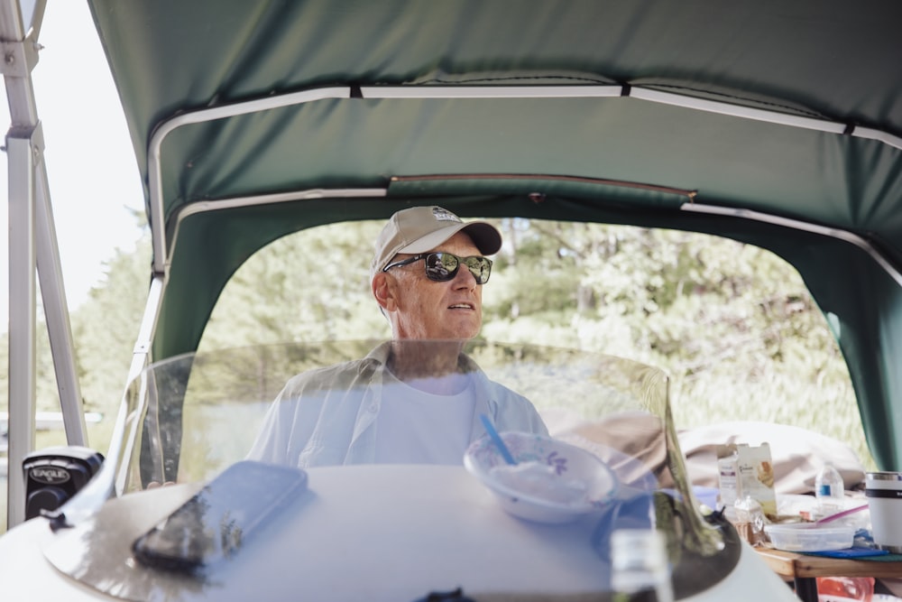 man in white dress shirt wearing sunglasses sitting on car seat