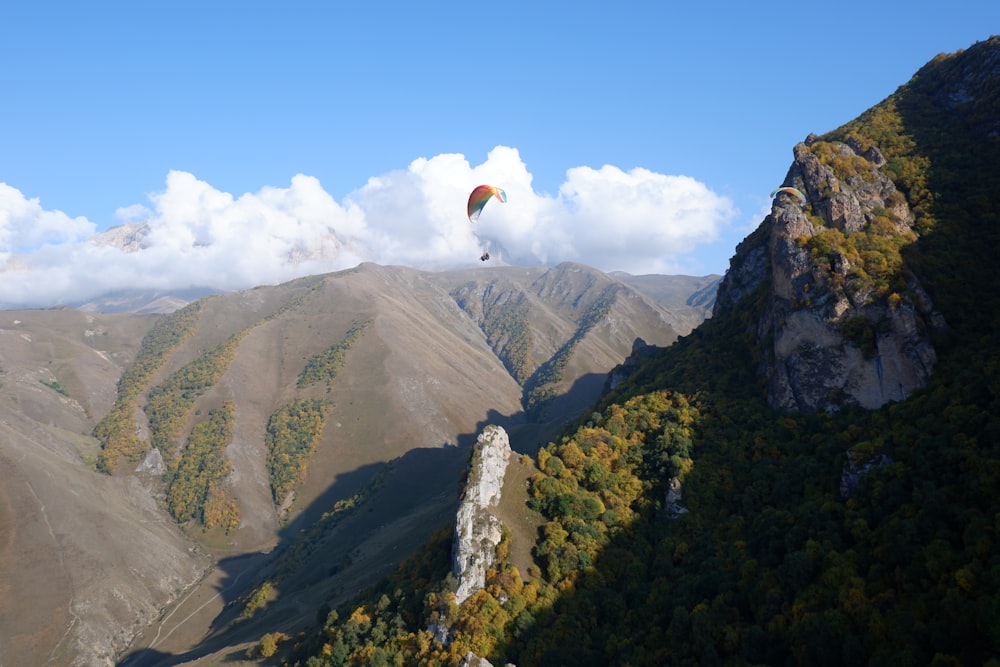 person in white shirt standing on top of mountain during daytime