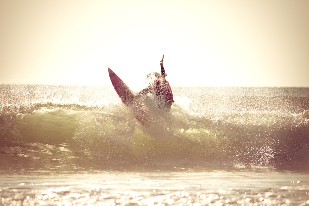 man surfing on sea waves during daytime