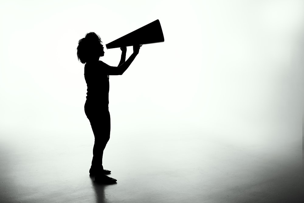 silhouette of woman holding rectangular board