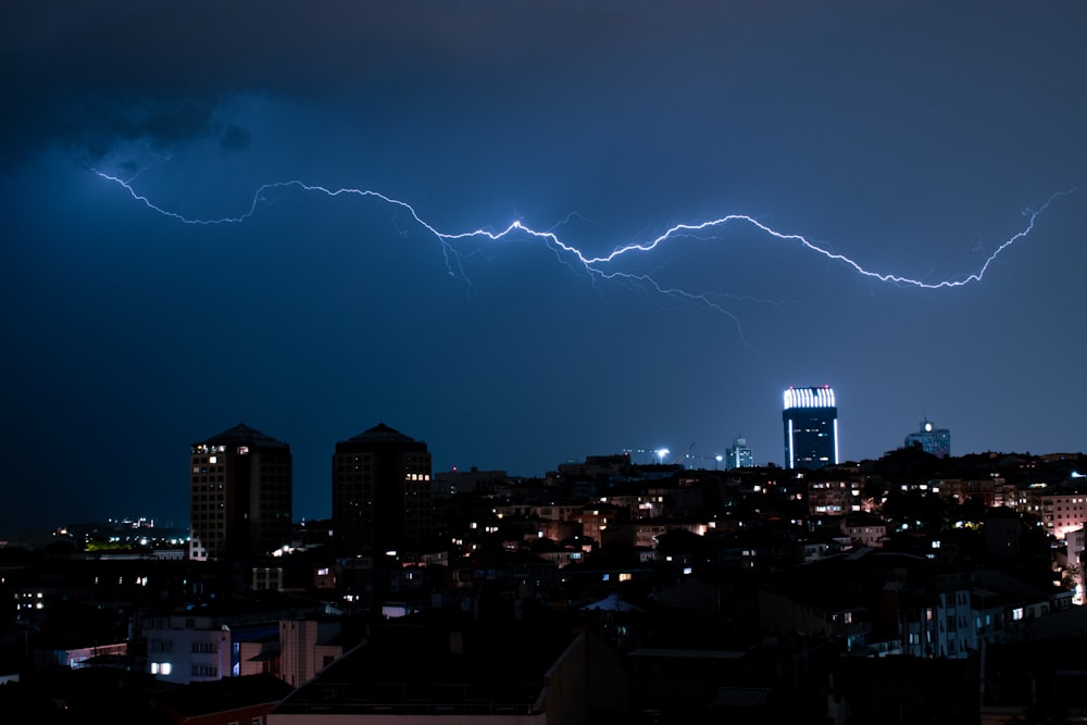 a lightning bolt strikes over a city at night