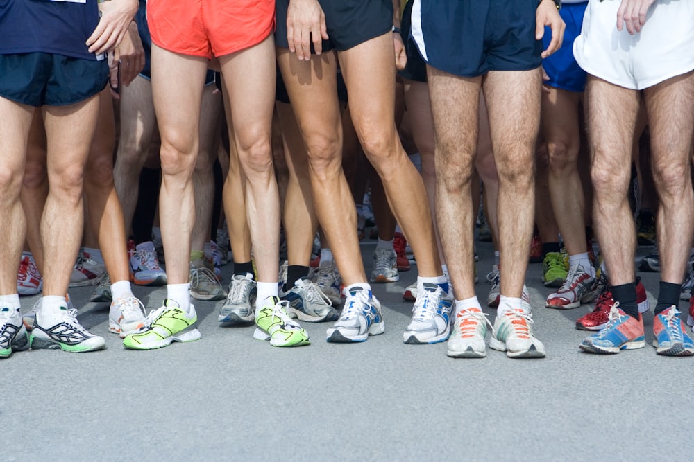 man in blue shorts and white nike sneakers