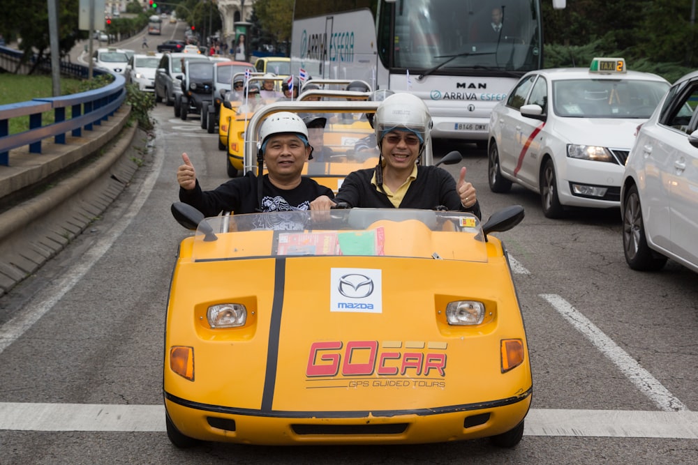 2 children riding yellow ride on car