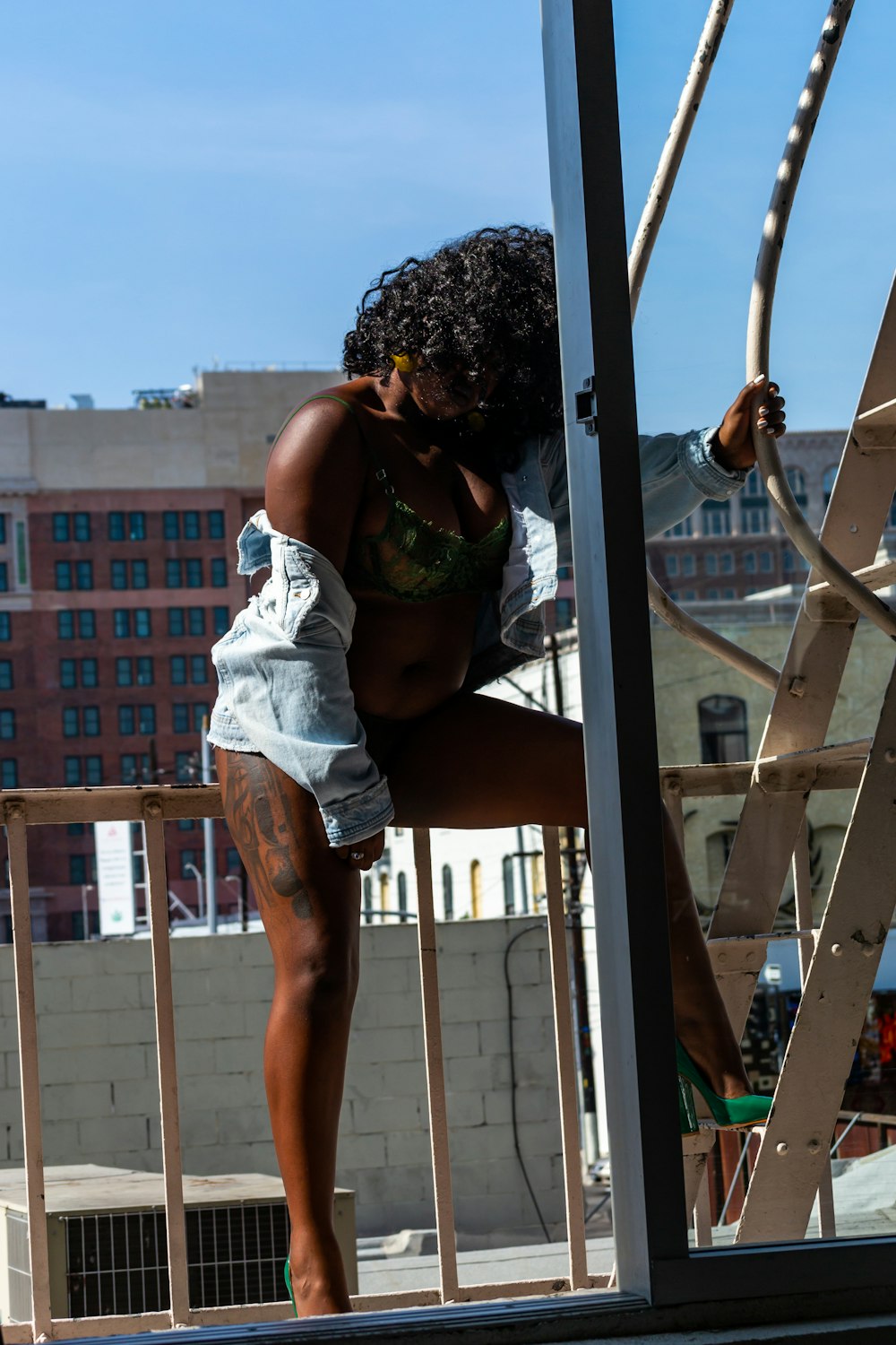 woman in white and green floral dress leaning on gray metal railings during daytime