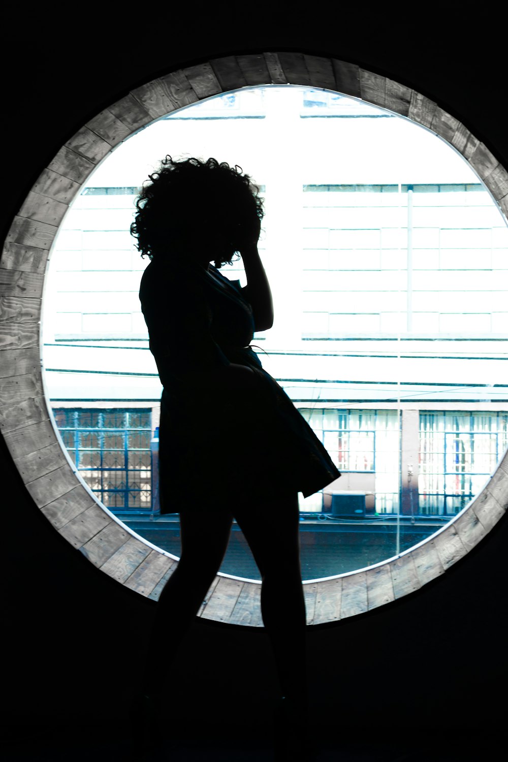 woman in black dress standing on round tunnel