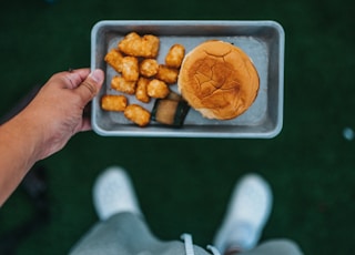 person holding tray with fried food