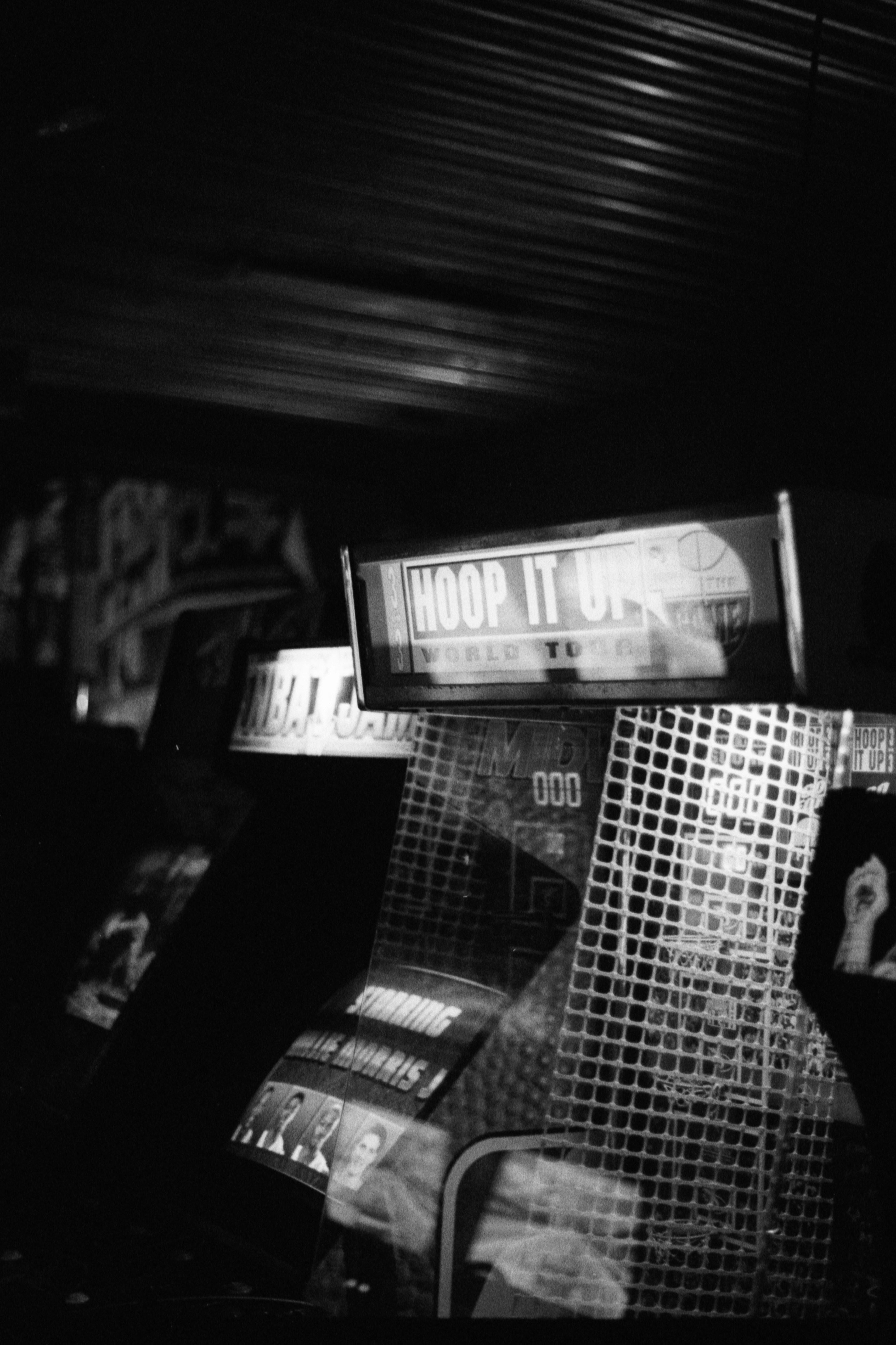 grayscale photo of man in black suit standing near store