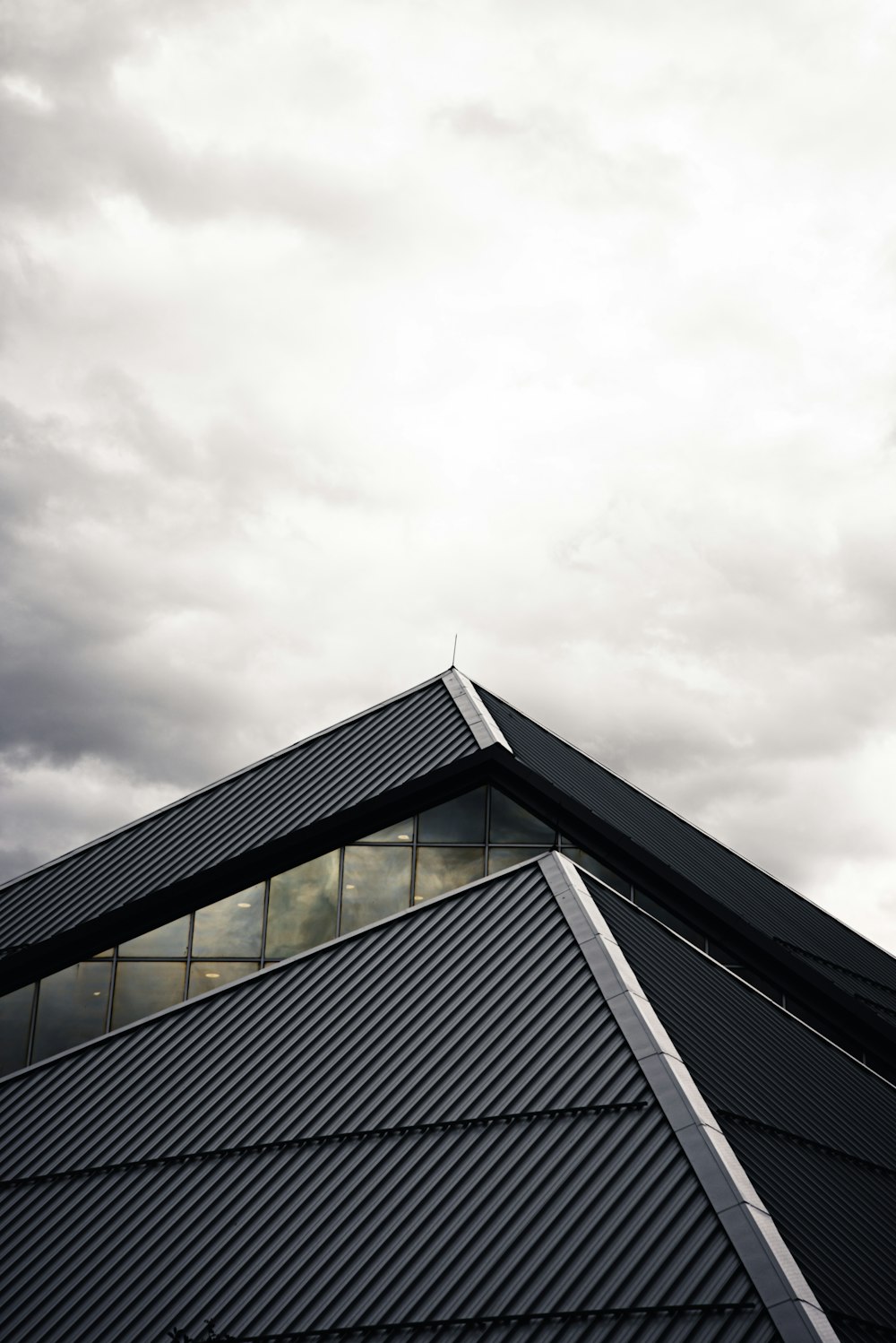 edifício cinza e preto sob nuvens brancas