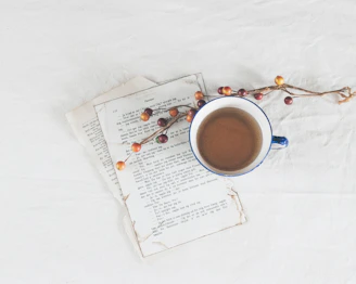 Close-up of a rustic wooden terrace with a coffee cup and a book, framed by natural stone walls.