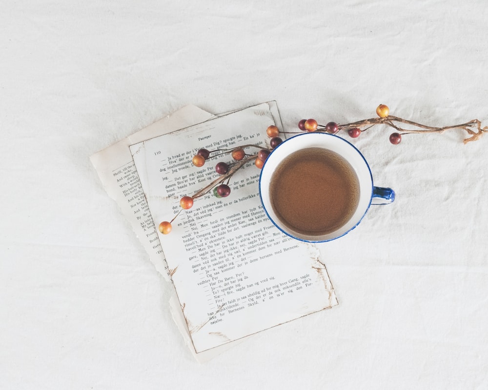 Taza de cerámica blanca sobre papel de impresora blanco