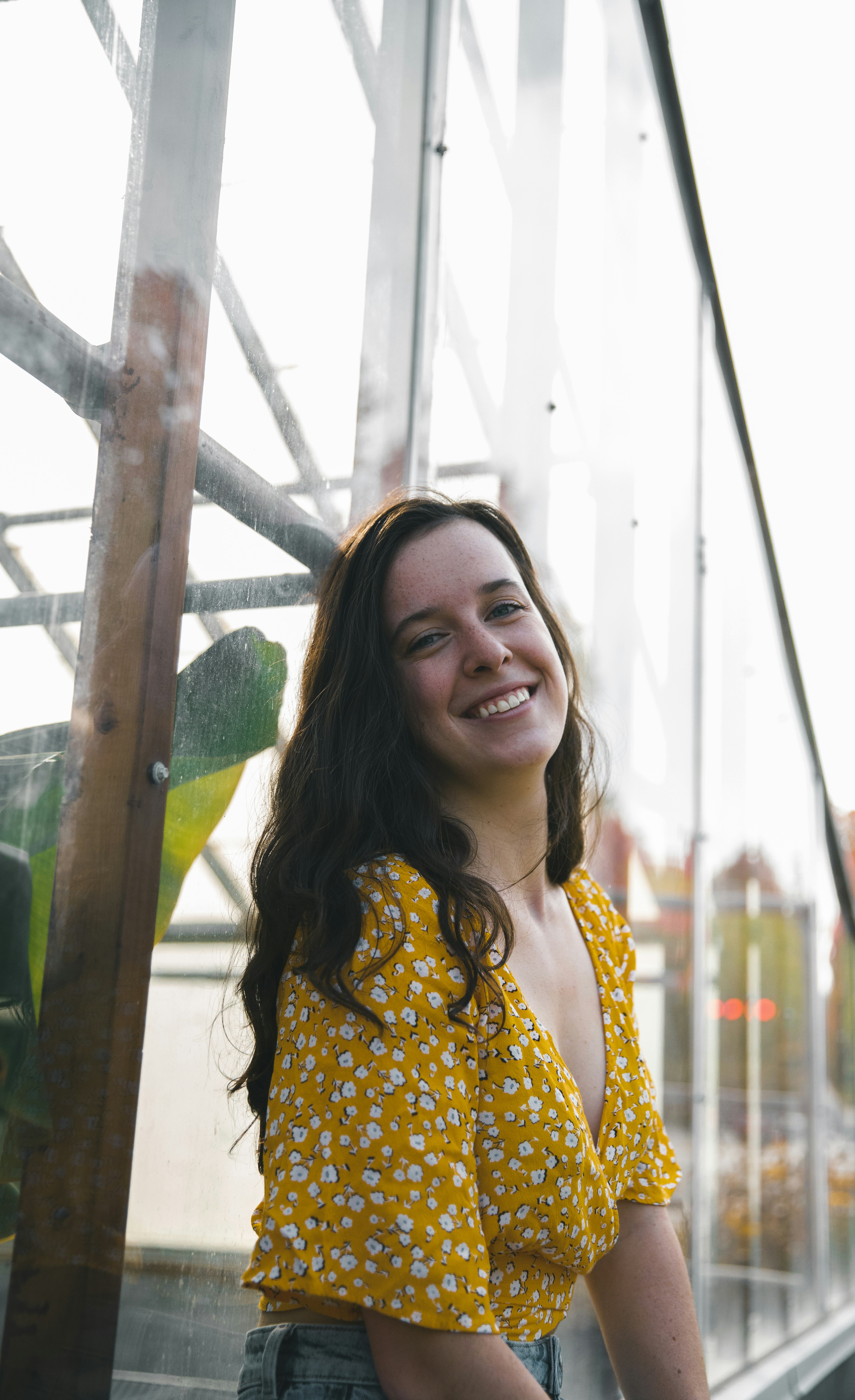 smiling woman in yellow and white floral dress