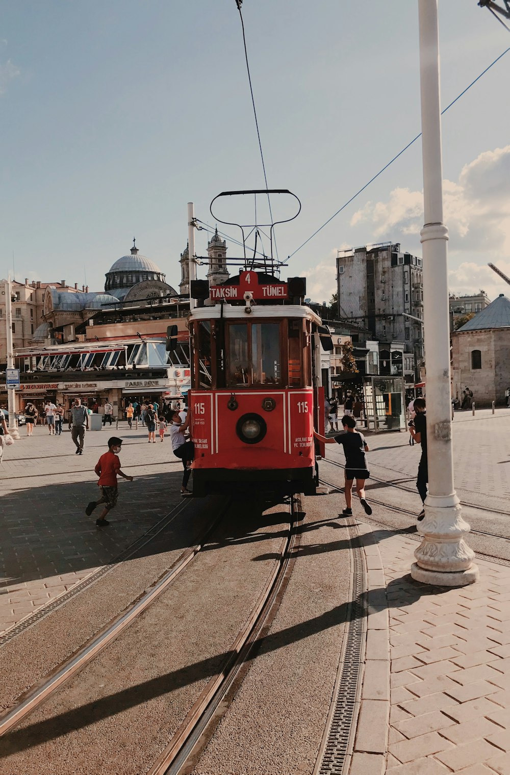 red and white tram on the street during daytime