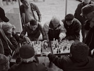 A diverse group of learners of all ages engaged in a lively chess lesson.