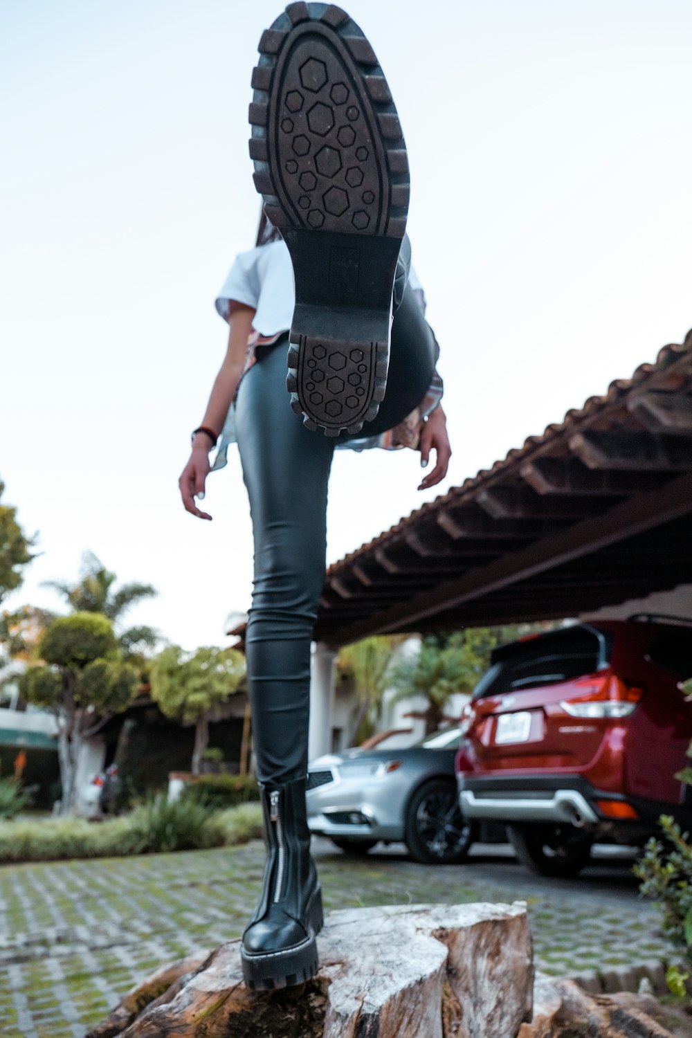 woman in black and white shirt and blue denim jeans standing on red roof during daytime