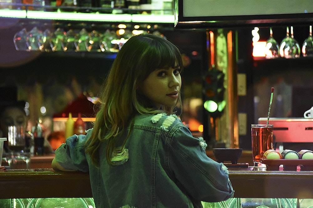 woman in green hoodie standing near counter