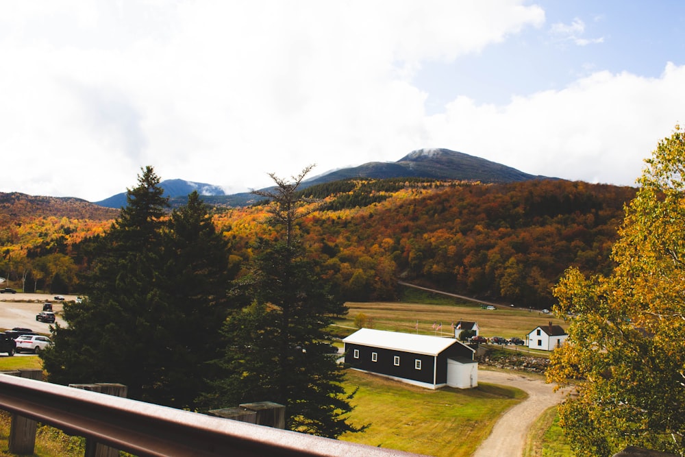 white and black house near green trees and mountain during daytime