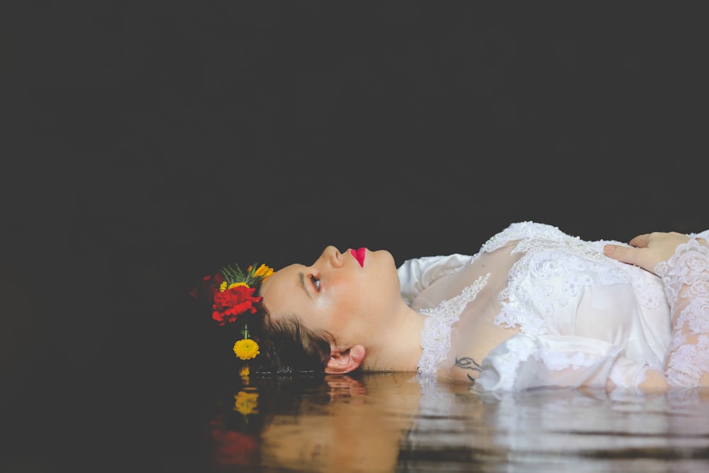 girl in white dress lying on water