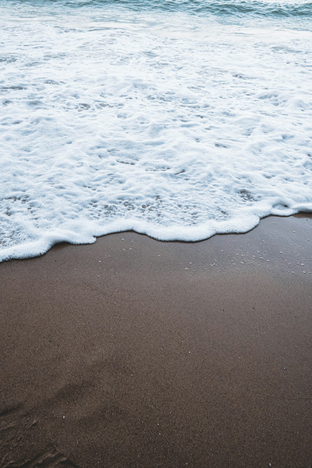 sea waves crashing on shore during daytime