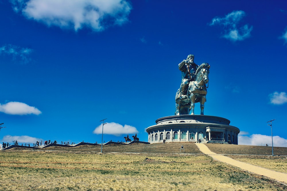 man riding horse statue under blue sky during daytime