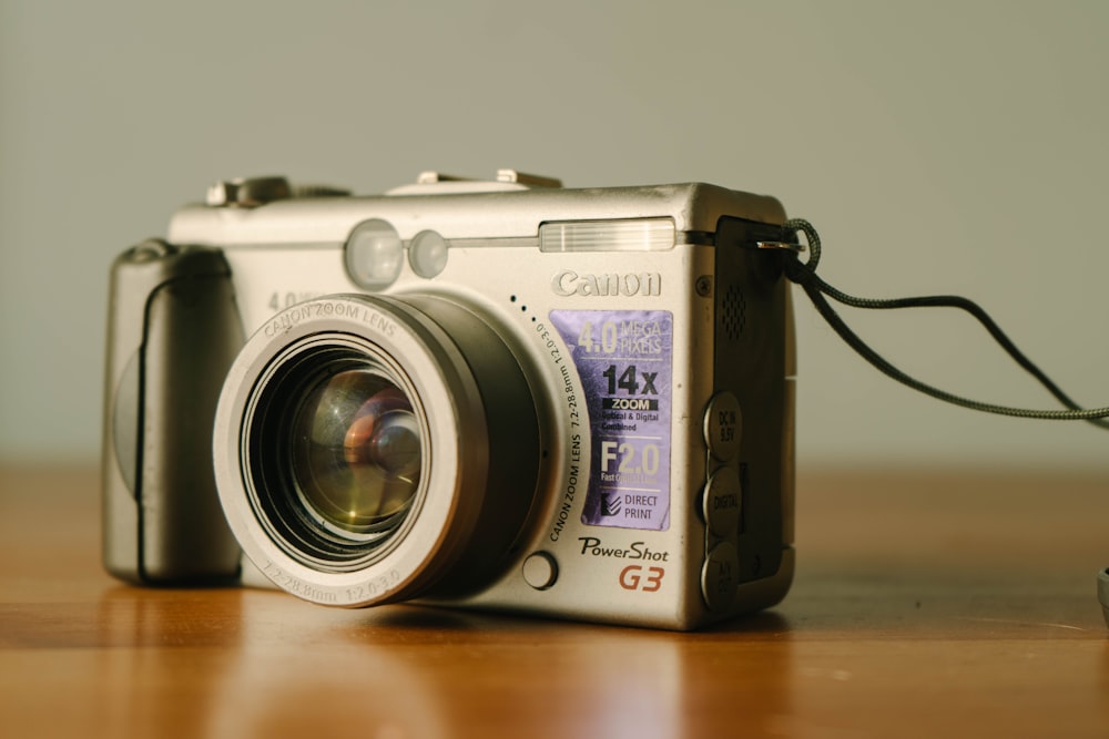 silver and black camera on brown wooden table