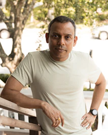 man in white crew neck t-shirt sitting on white wooden bench during daytime