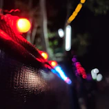 Close-up of app-controlled outdoor lights shifting through vibrant colors at dusk.