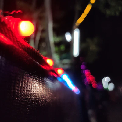 Close-up of shimmering rave accessories with LED lights glowing in a dark setting.