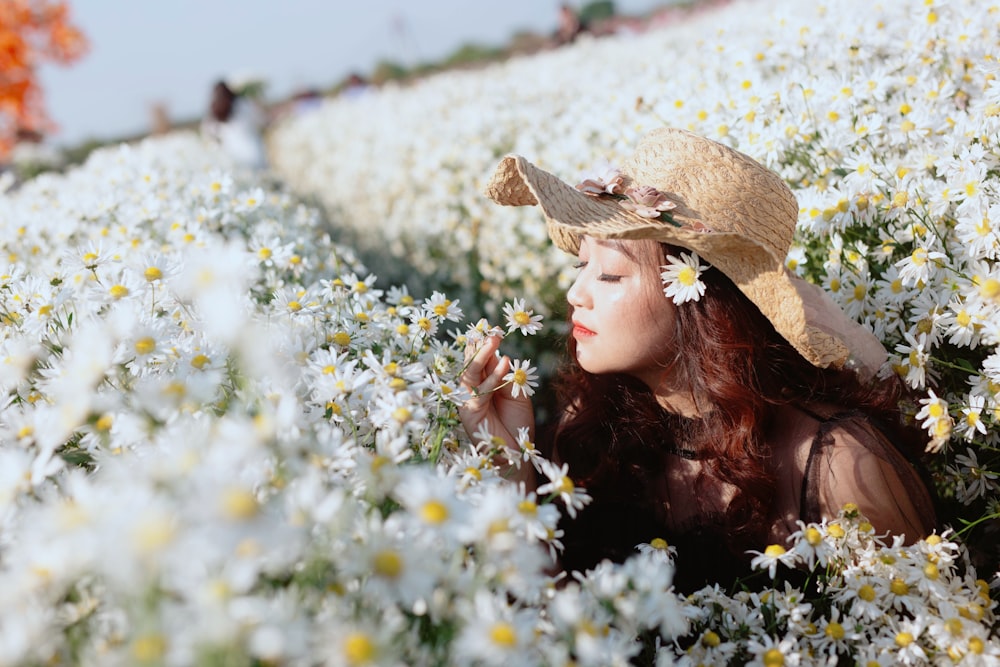 woman in brown sun hat on white flower field during daytime