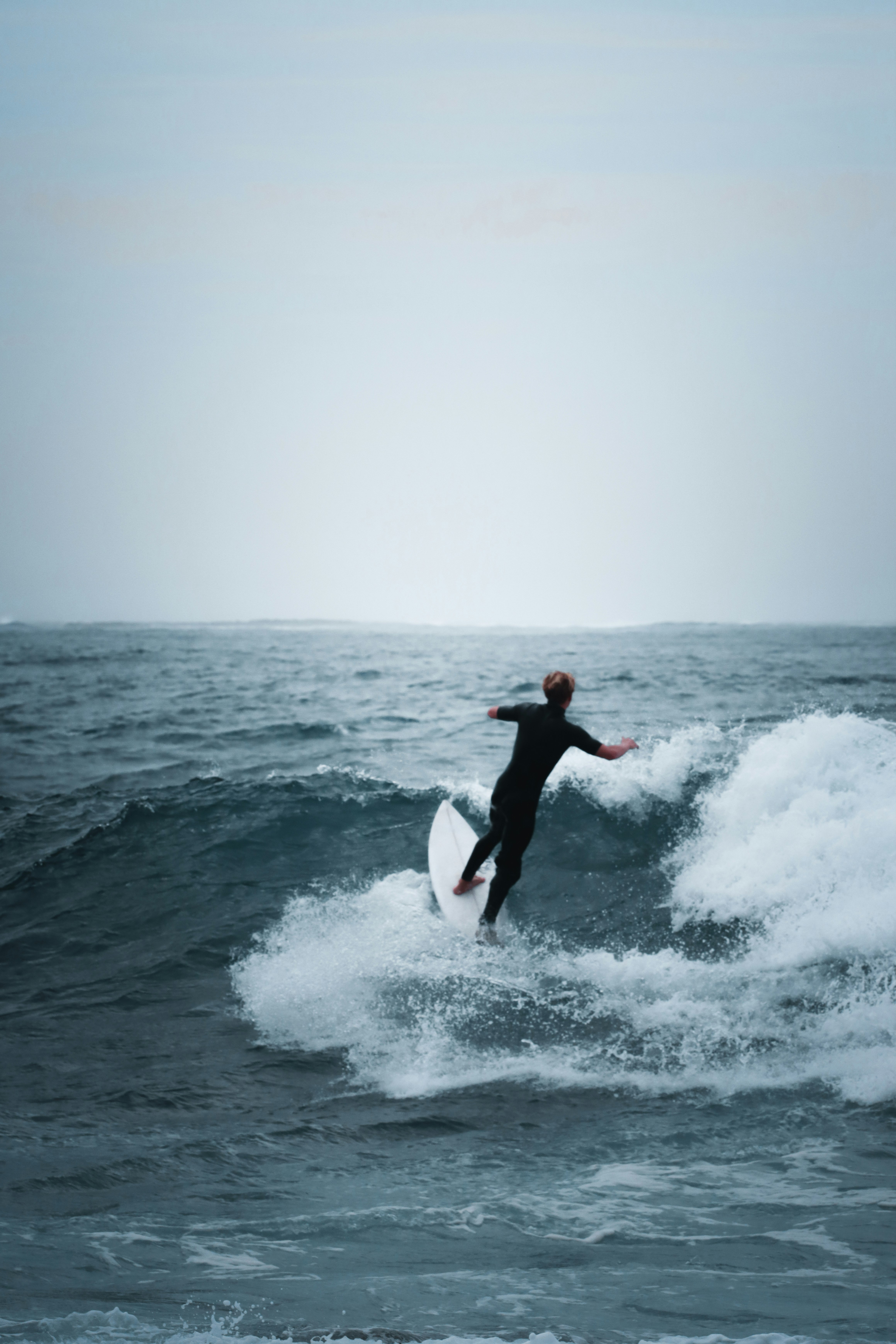 person surfing on sea waves during daytime