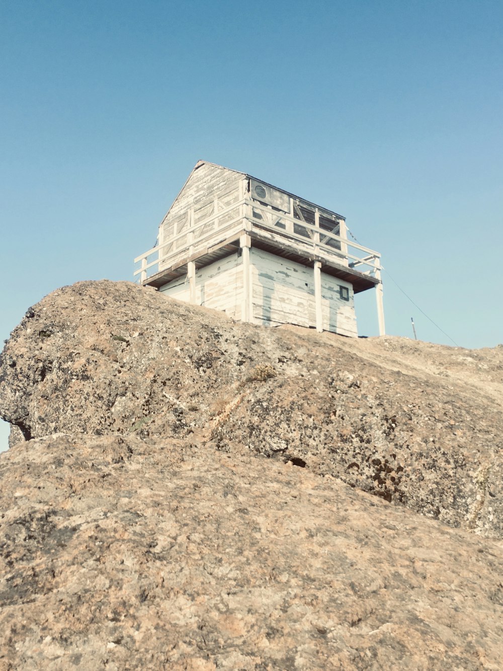 white concrete building on brown rock mountain under blue sky during daytime