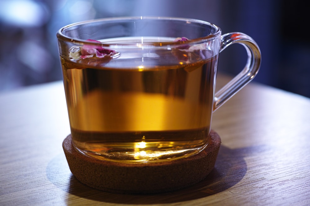 clear glass mug with brown liquid