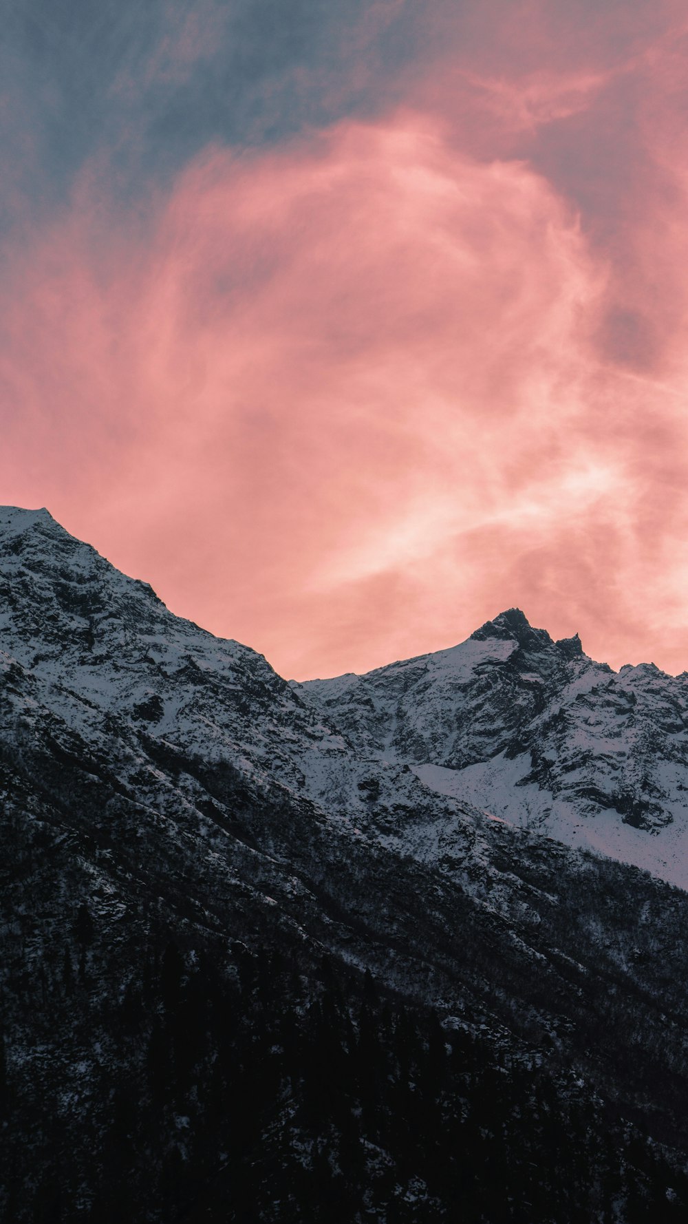 snow covered mountain under orange sky