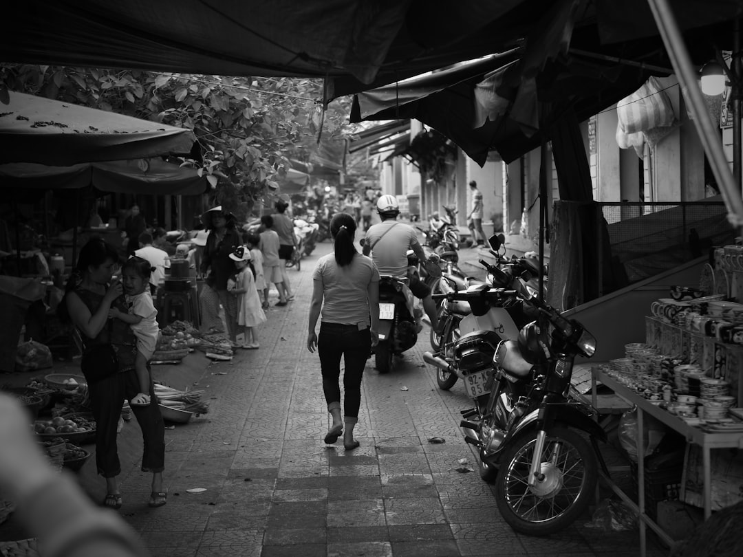 grayscale photo of people walking on sidewalk